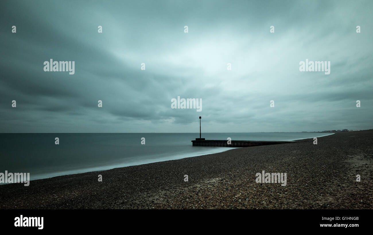 Moody long exposure photo of the beach at Hythe, Kent. Low key and minimal features. Stock Photo