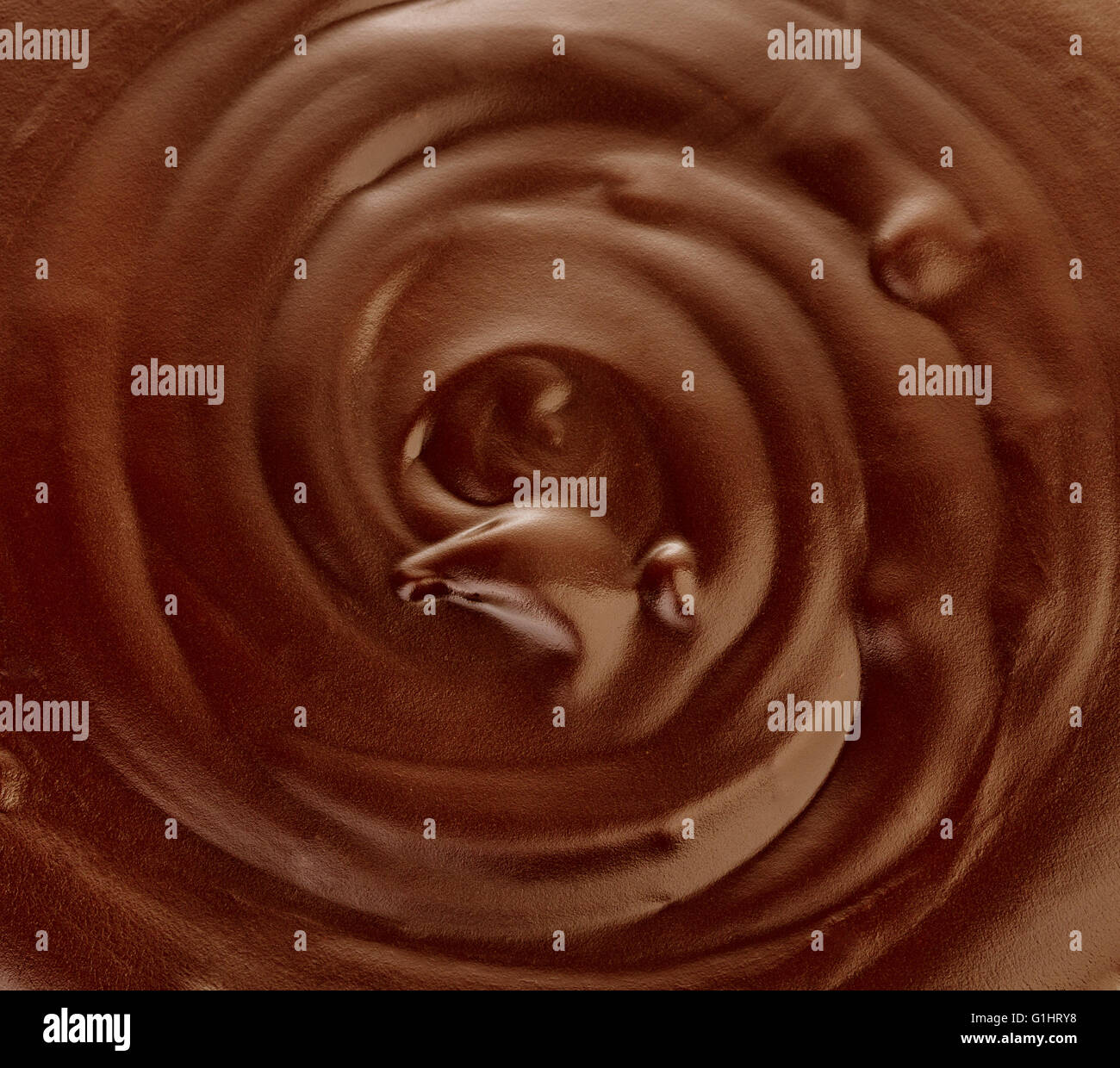 Melted dark chocolate flow, candy or chocolate preparation close-up as a background. Stock Photo