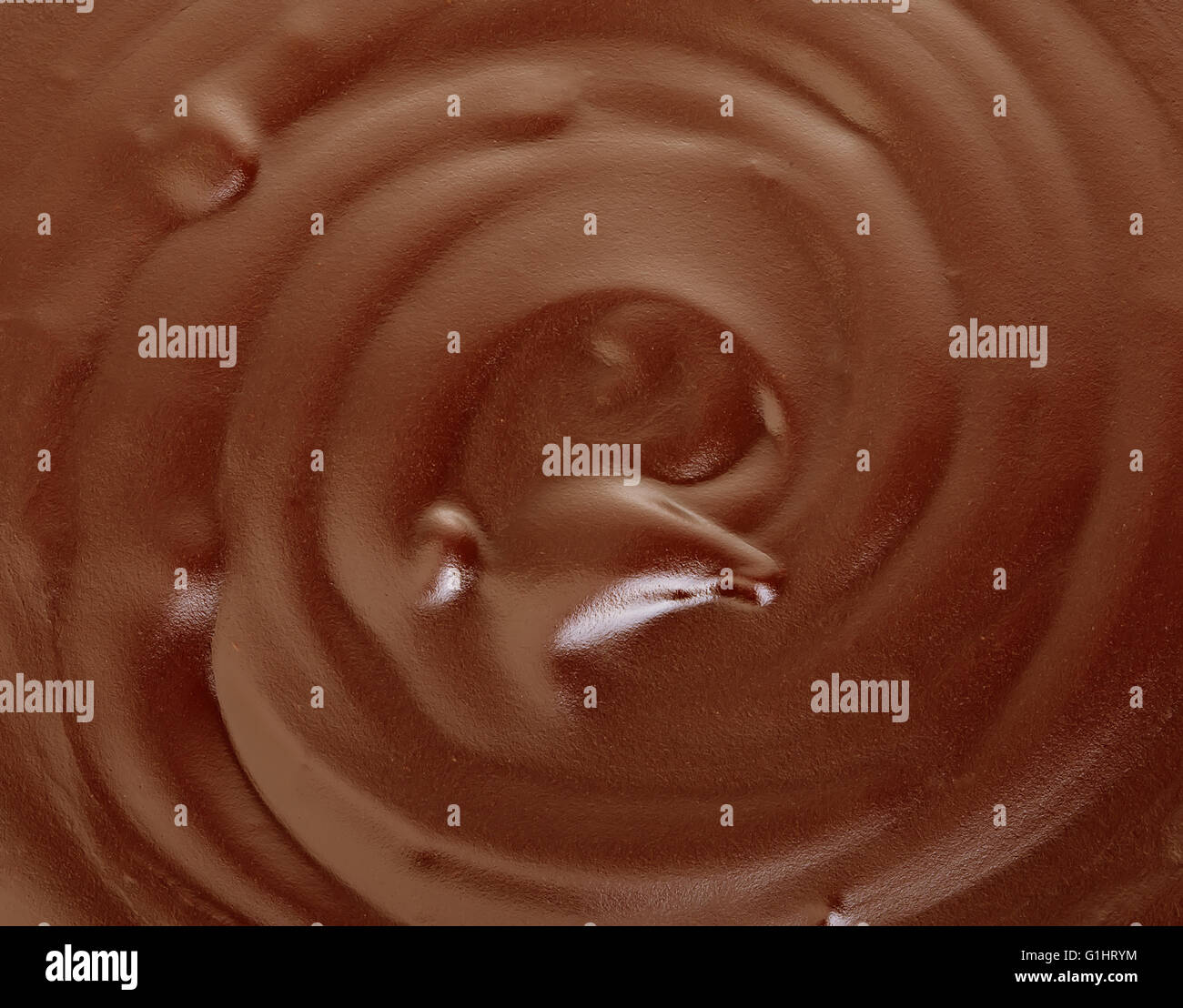 Melted dark chocolate flow, candy or chocolate preparation close-up as a background. Stock Photo