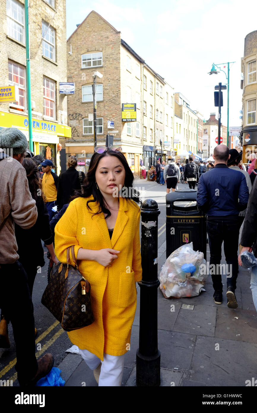 classy Oriental woman with Louis Vuitton handbag on Brick Lane in East London Stock Photo