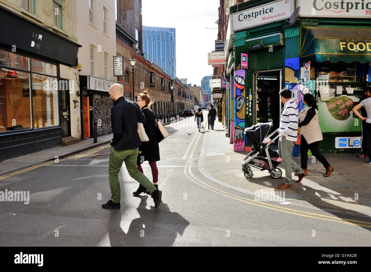 couples crossing road in East London Stock Photo