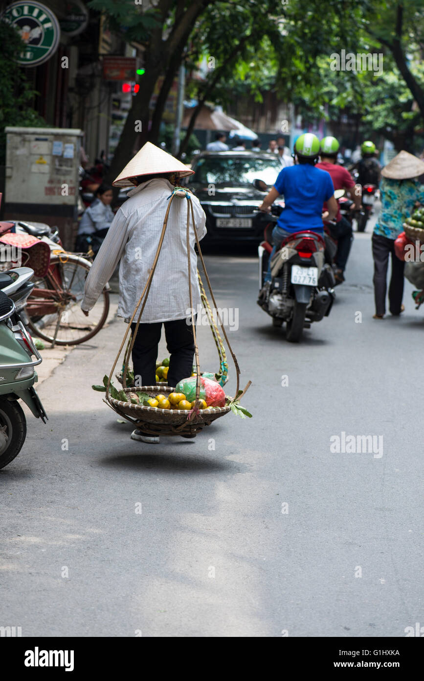 Vietnamese woman carrying fruit in baskets, Old Hanoi Stock Photo