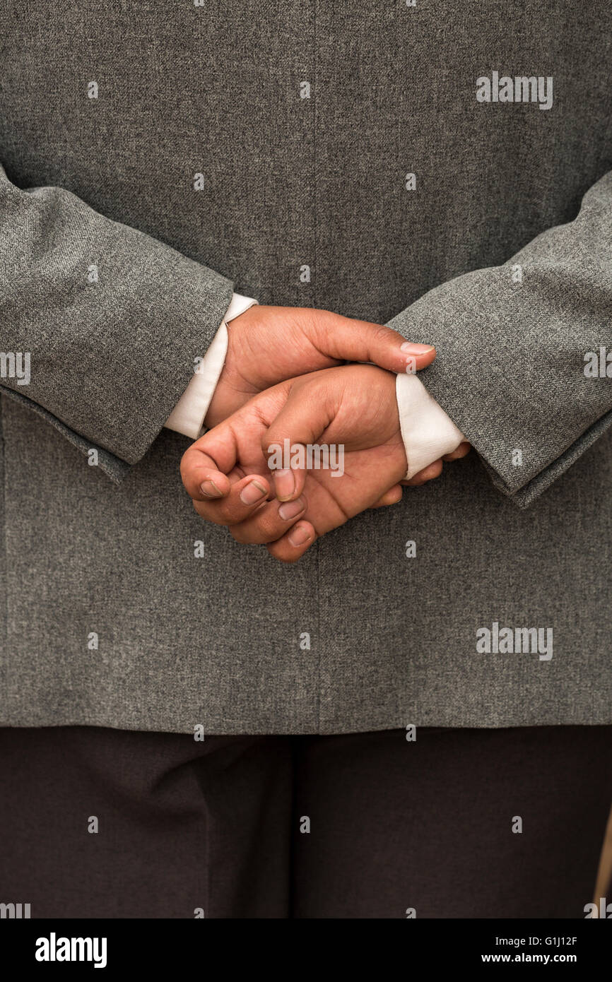 Mans hands clasped behind his back. Stock Photo