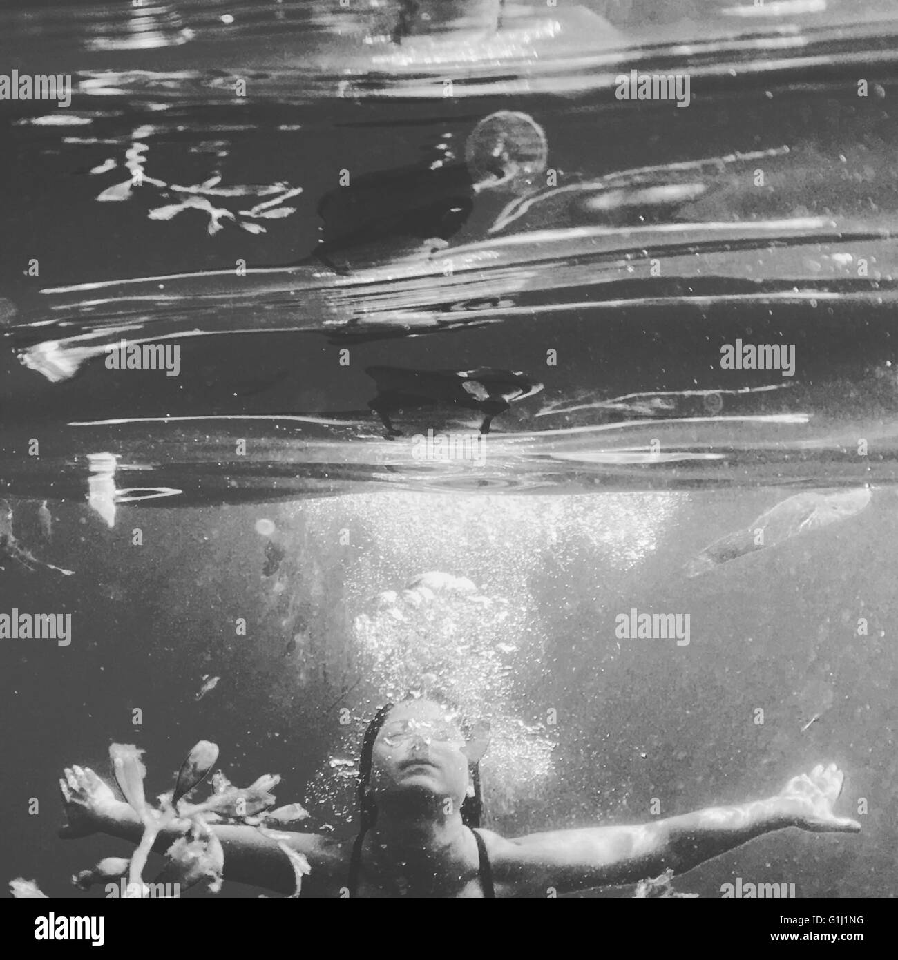 Woman swimming underwater in ocean Stock Photo