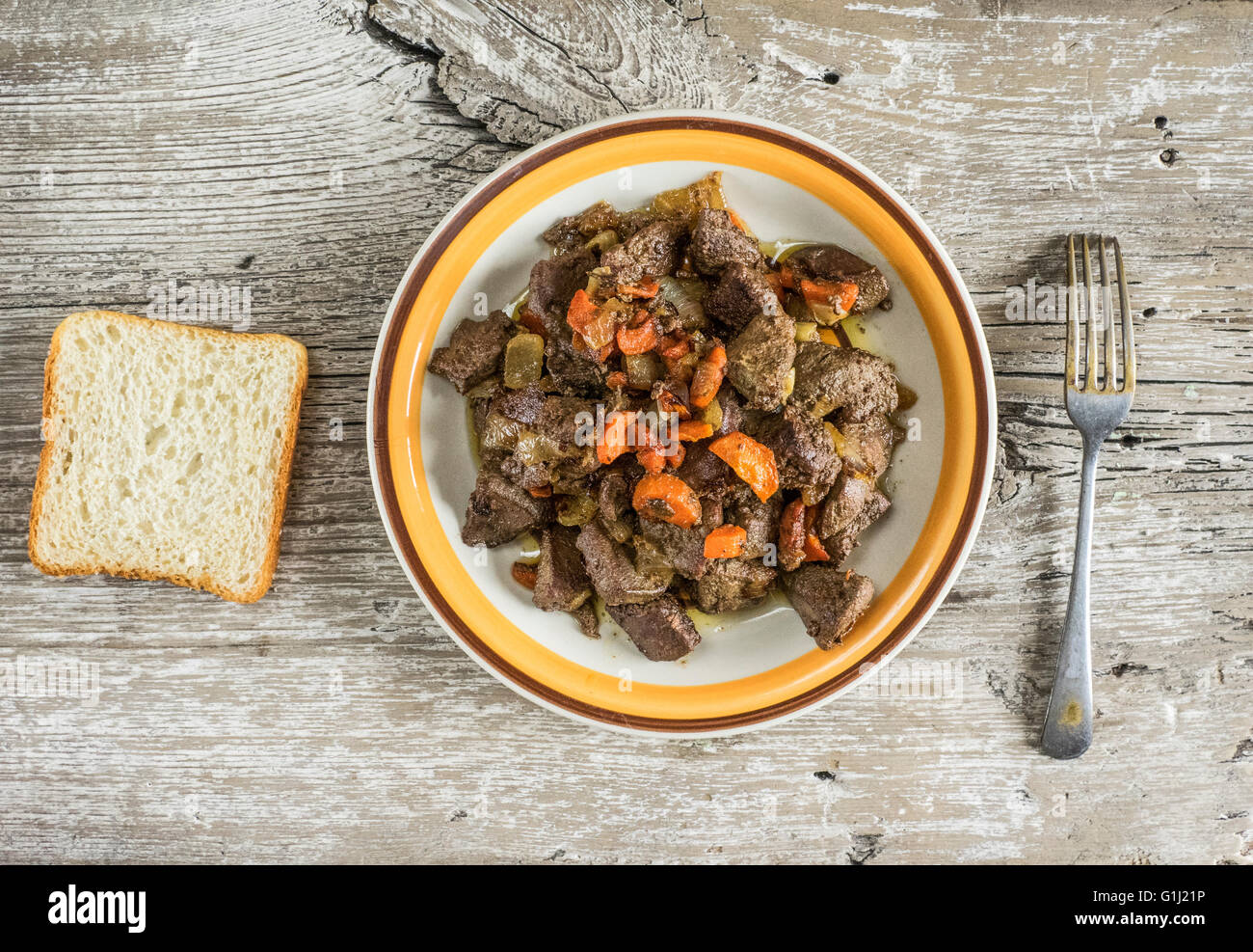 Plate of fried pork liver with slice of bread Stock Photo