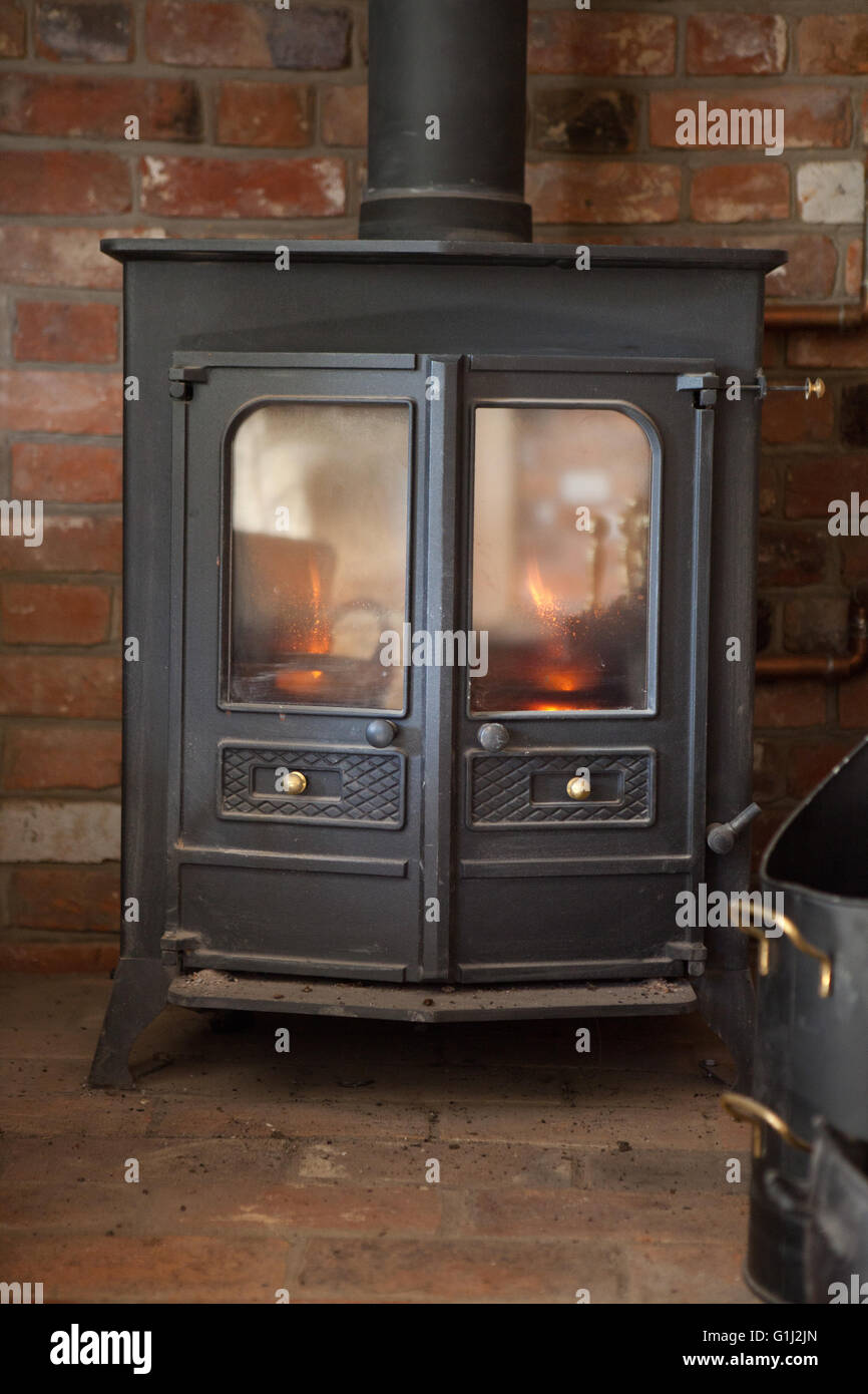A Charnwood 16B multifuel stove with back boiler using wood logs provides space heating, hot water and space heating. Stock Photo