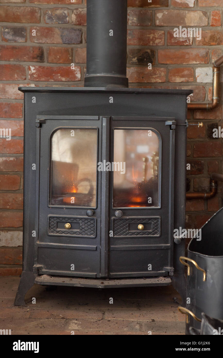 A Charnwood 16B multifuel stove with back boiler using wood logs provides  space heating, hot water and space heating Stock Photo - Alamy