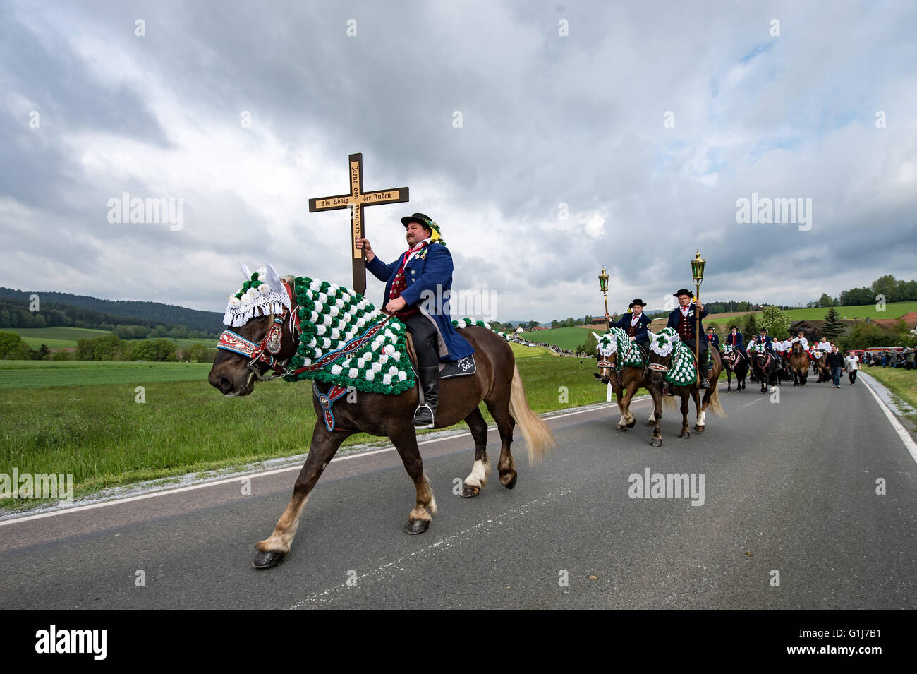 Bad Koetzing, Germany. 16th May, 2016. Participants in the Koetzing Pentecost Ride ride their horses near Bad Koetzing, Germany, 16 May 2016. The procession of 900 horsemen is one of the oldest traditional events in Bavaria. The 'Maennerleut' make an around seven-kilometer pilgrimage on the back of richly adorned horses from Bad Koetzting to St. Nicholas' Church in Steinbuehl. Photo: ARMIN WEIGEL/dpa/Alamy Live News Stock Photo