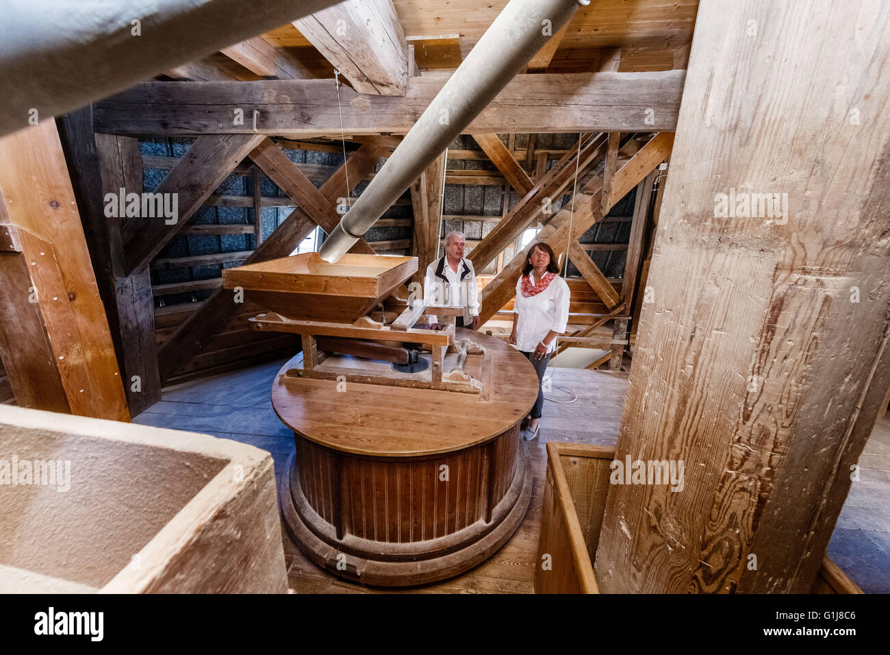 Braak, Germany. 13th May, 2016. Karl-Hermann Vahle, president of the Mill Association, and Maren Lessau from the Mill Association, inspect the grinder in the Braak windmill in Braak, Germany, 13 May 2016. The windmill is one of 52 wind and watermills open to the public on 16 May 2016, German Mills Day. Photo: Markus Scholz/dpa/Alamy Live News Stock Photo