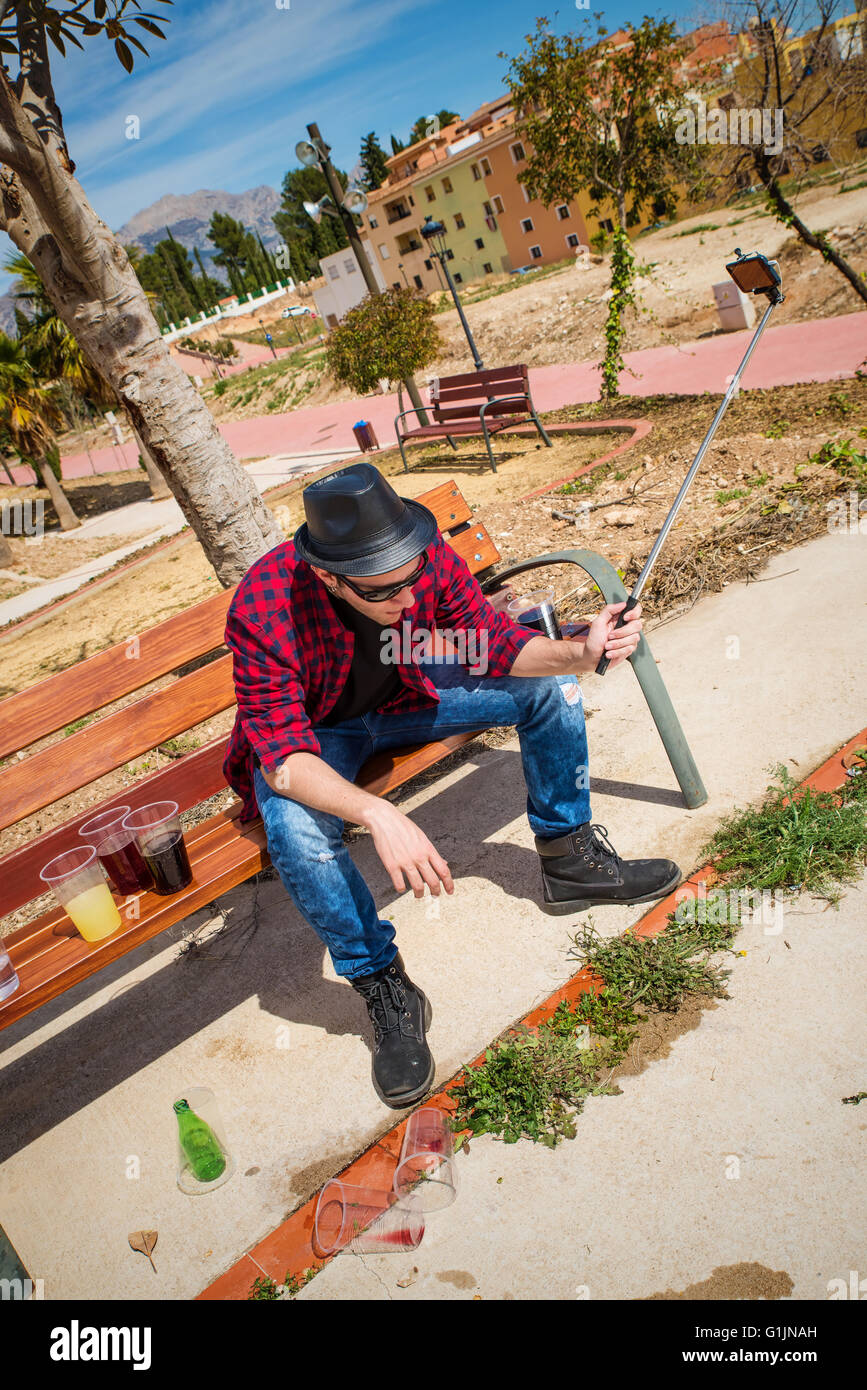 Guy throwing up on a park bench while taking a selfie Stock Photo Alamy