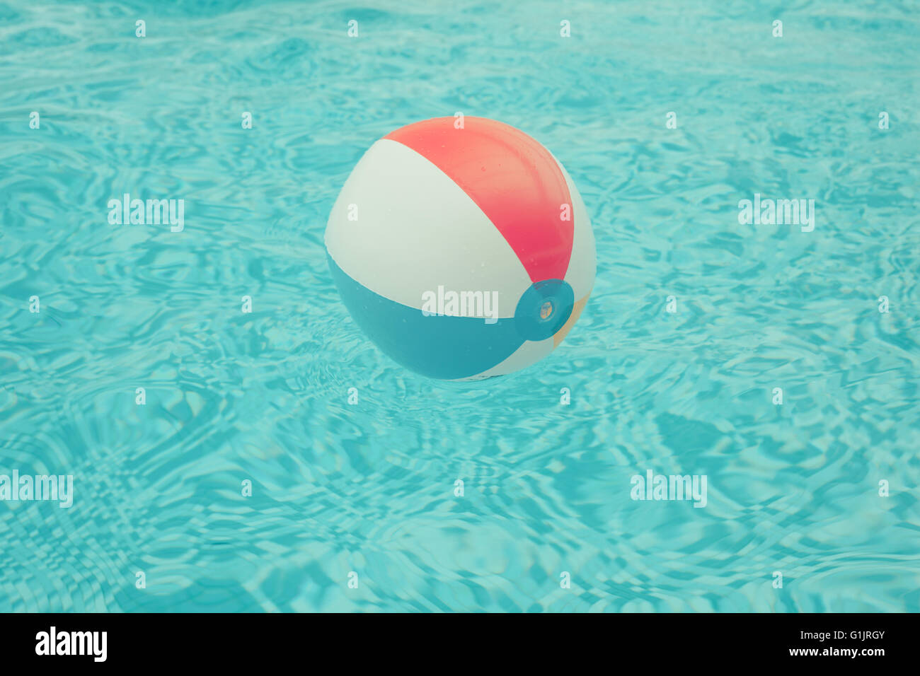 A beach ball is floating in a swimming pool Stock Photo