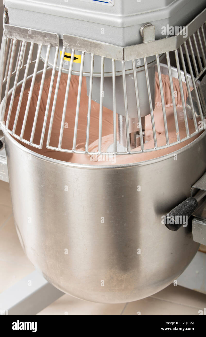 chef is preparing cake mix in industrial bread mixer kneading machine