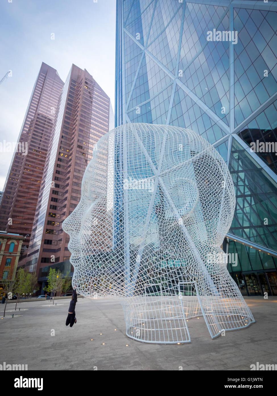 A view of the sculpture Wonderland by Jaume Plensa, in front of The Bow skyscraper in Calgary, Alberta, Canada. Stock Photo