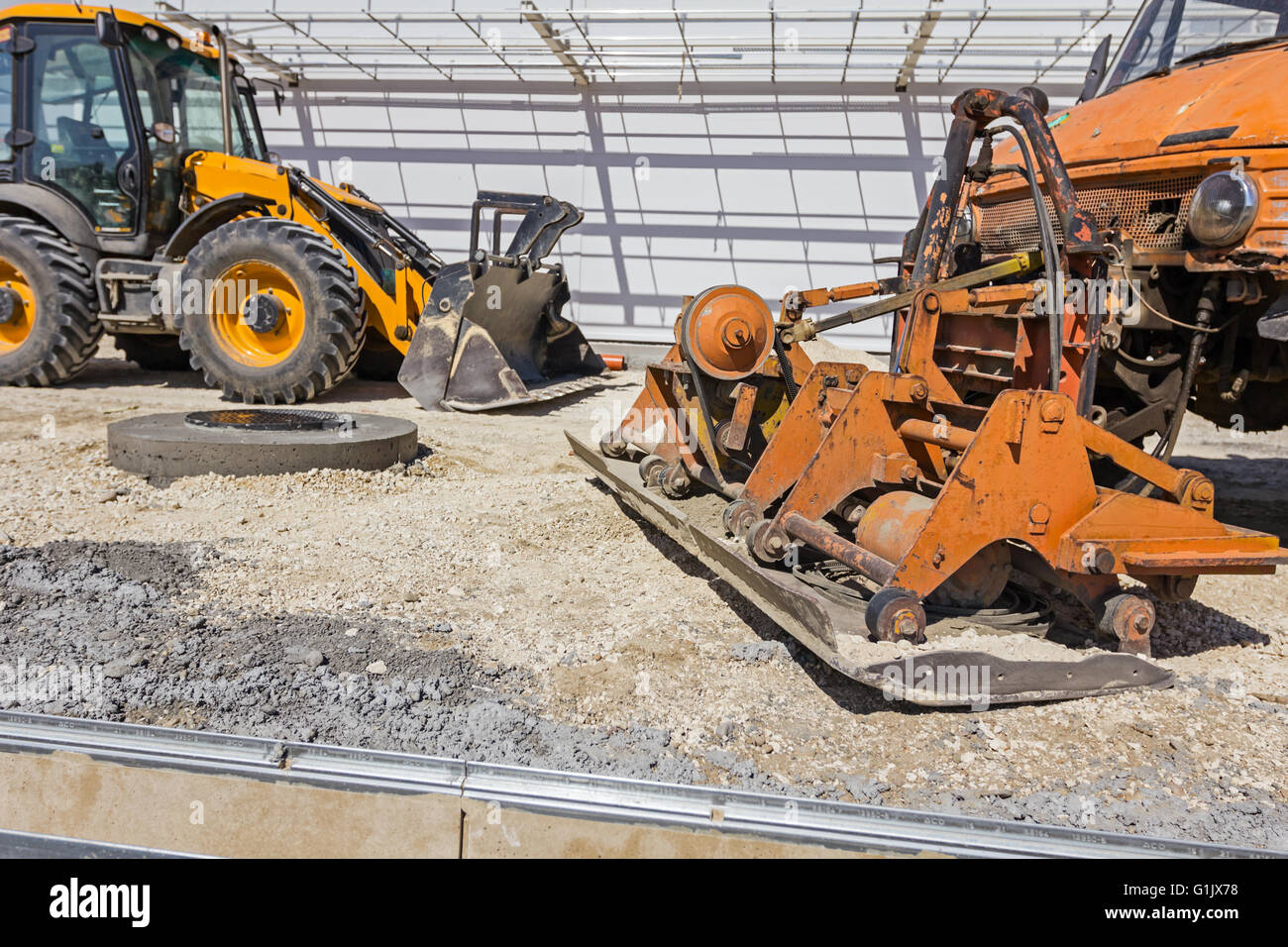 Plate compactor is mounted to the truck, compacting sand at road