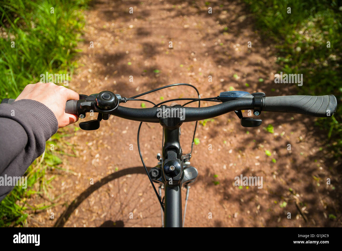hand on bicycle handlebar on bike lane in nature Stock Photo