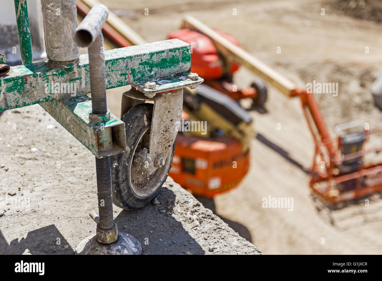 Side wheel of the scaffolding is secured at the building edge. Mobile scaffold wheel close up. Stock Photo