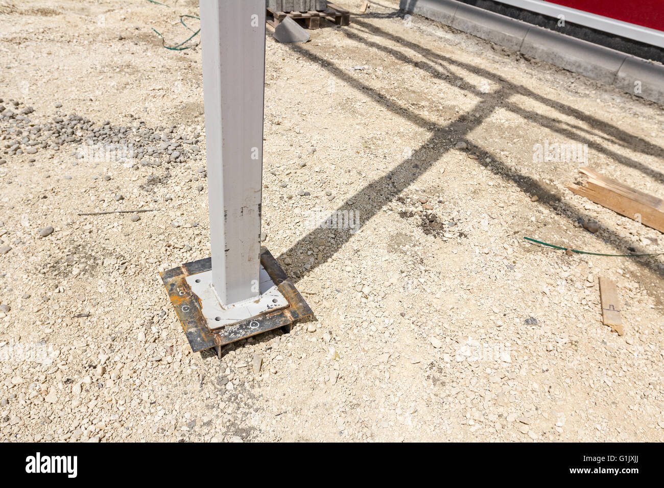 White steel pillar is welded to the foundation. Shadow of frame above