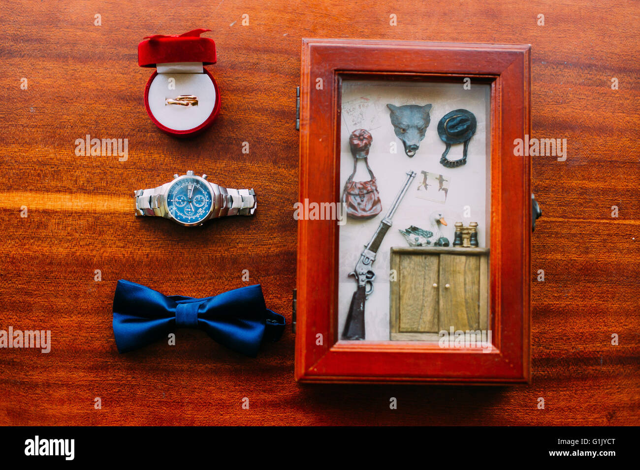 Best man accessories: bow tie, modern watch, souvenir and wedding rings in  small red box Stock Photo - Alamy