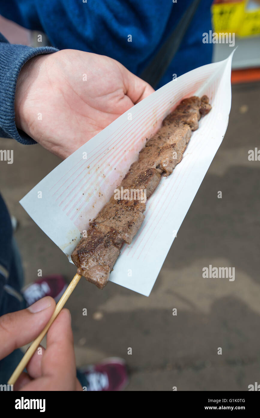 Cooked beef steak on stick ready to eat Stock Photo