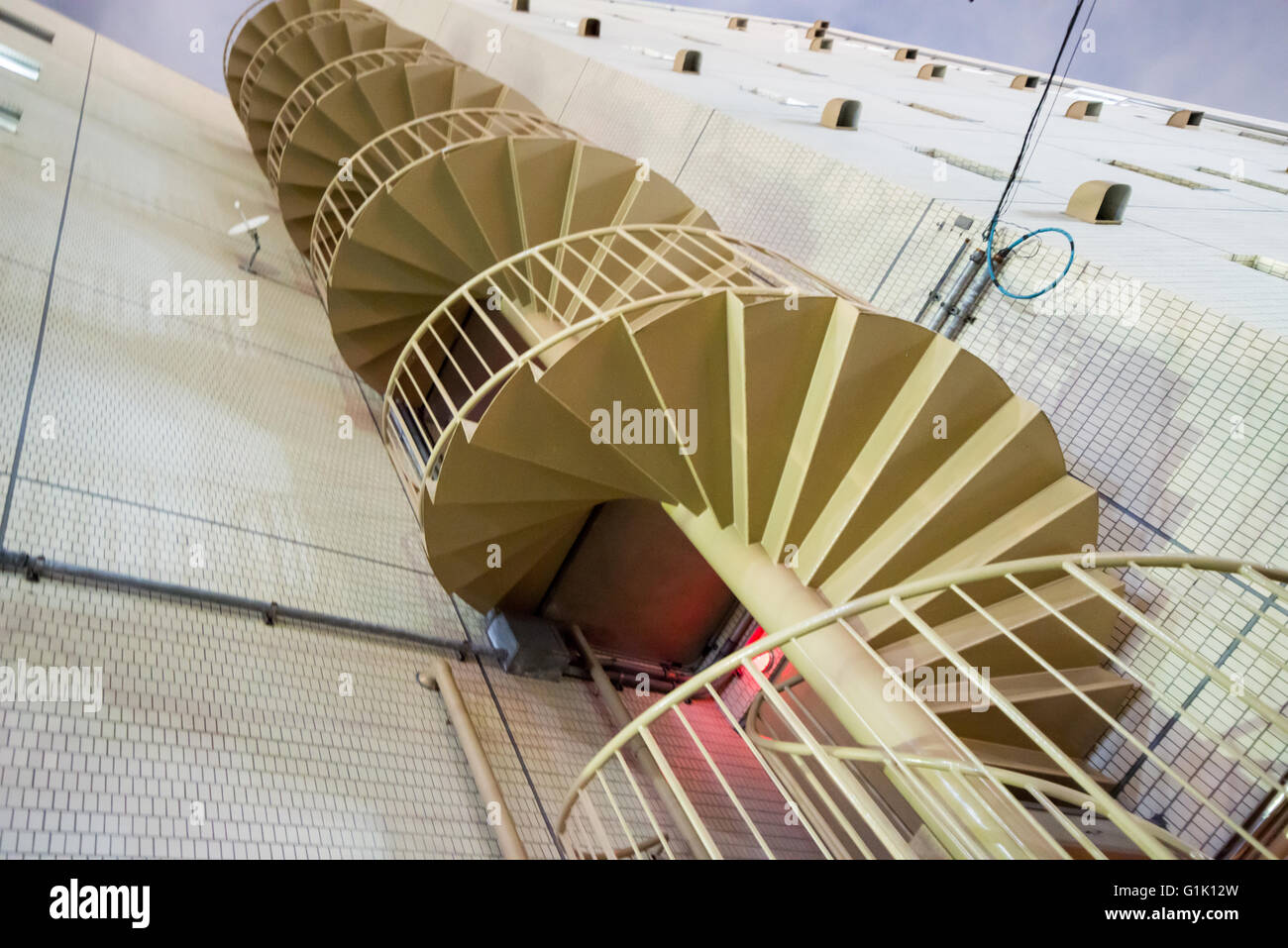 Spiraling metal staircase on outside of building Stock Photo