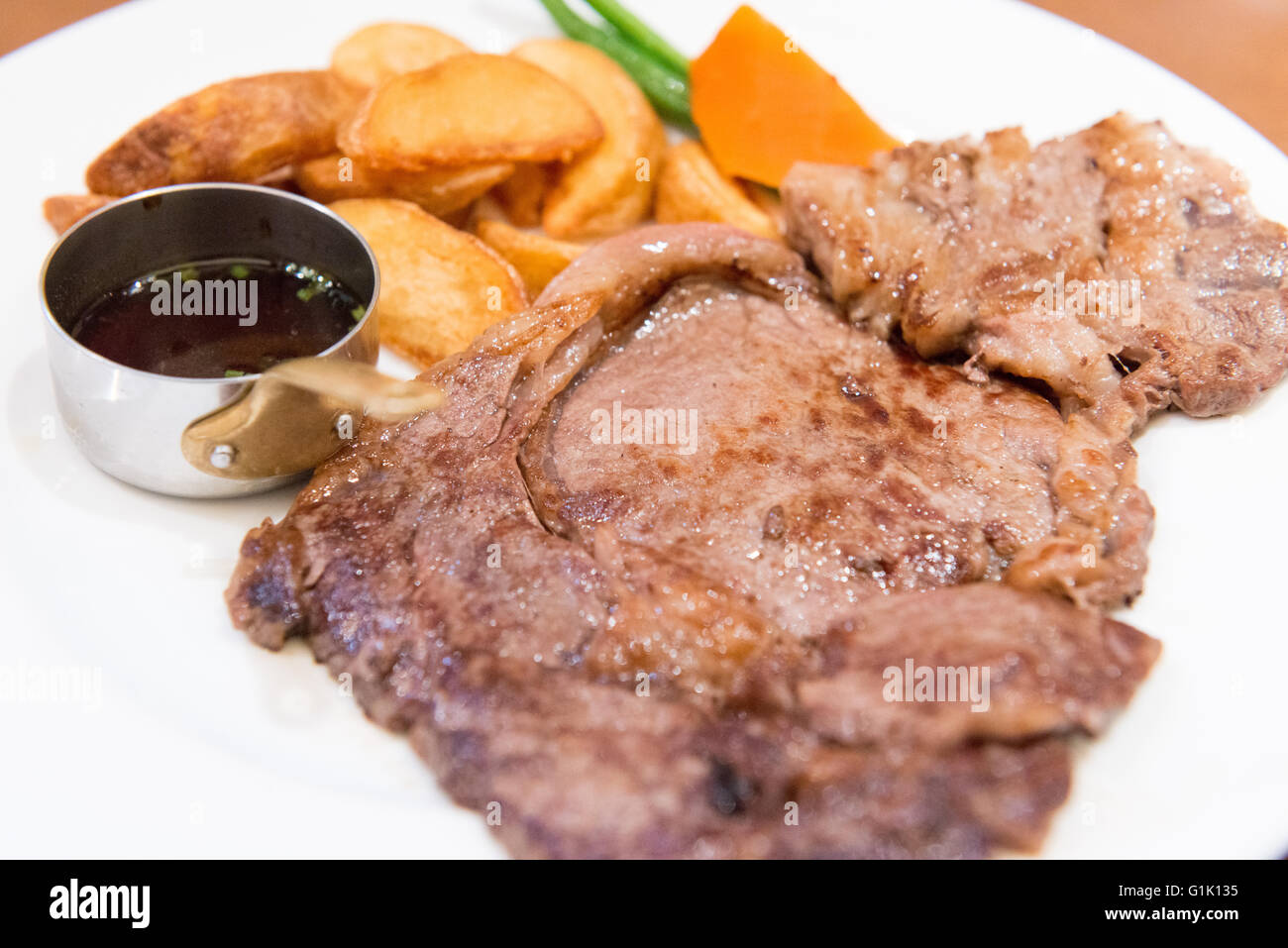A large portion of beef steak and chips on plate Stock Photo