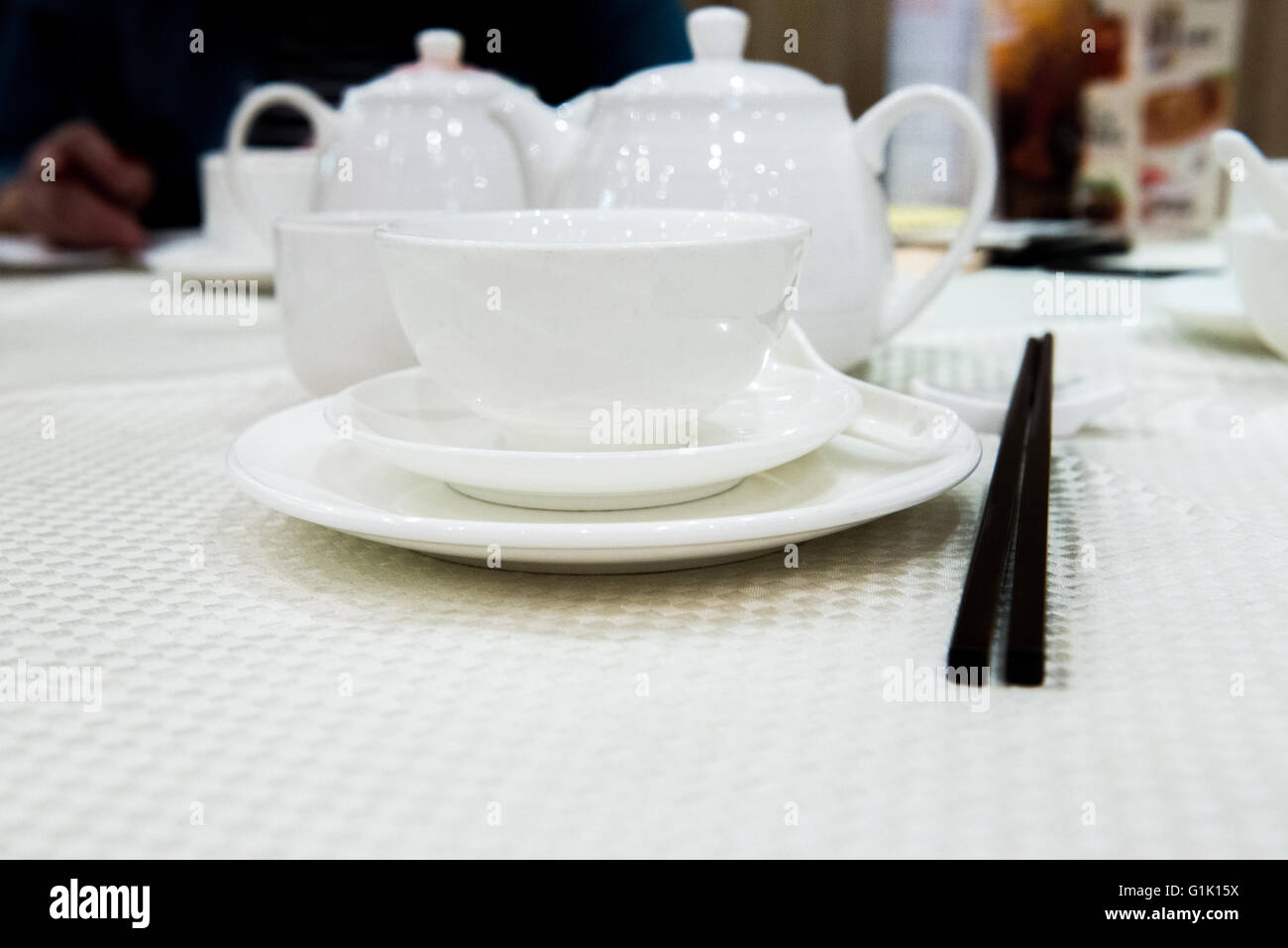 White tea pot and cups at a Chinese traditional dinner in a restaurant Stock Photo