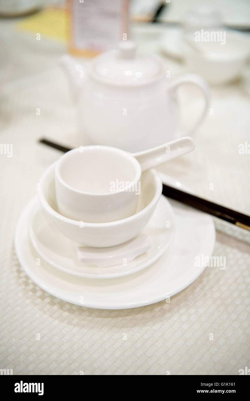 White tea pot and cups at a Chinese traditional dinner in a restaurant Stock Photo