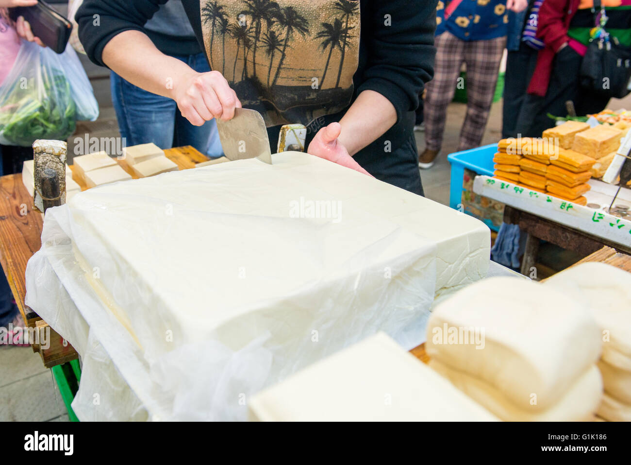 cutting large tofu block at market in Asia Stock Photo