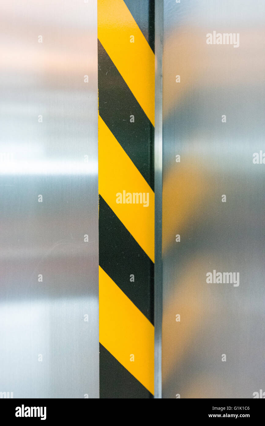 black and yellow lined sticker edge warning on elevator door Stock Photo