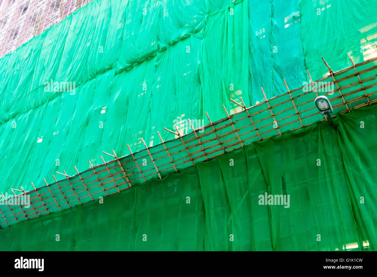 green sheets of netting covering building for safety Stock Photo