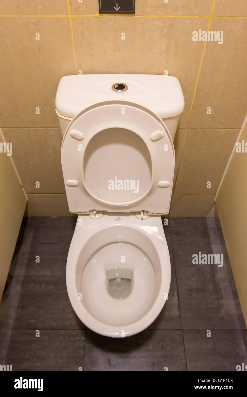 Clean white seat on lavatory toilet in cubical Stock Photo