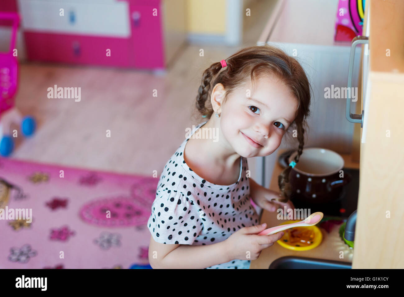 Little Girl With Braids Drawing Playing With Toy Kitchen