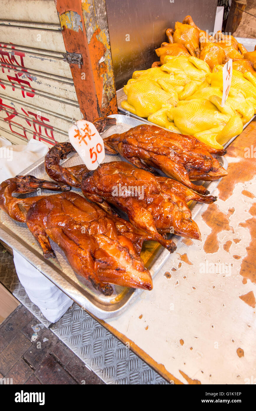 Whole roasted duck and chicken on trays at Chinese market Stock Photo