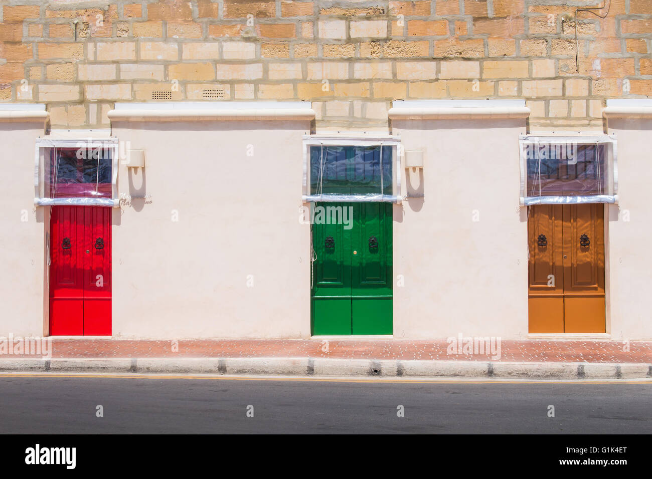 Neutral color of the facade of the house with colorful bright door. Building on the promenade of the fishing village Marsaxlokk, Stock Photo
