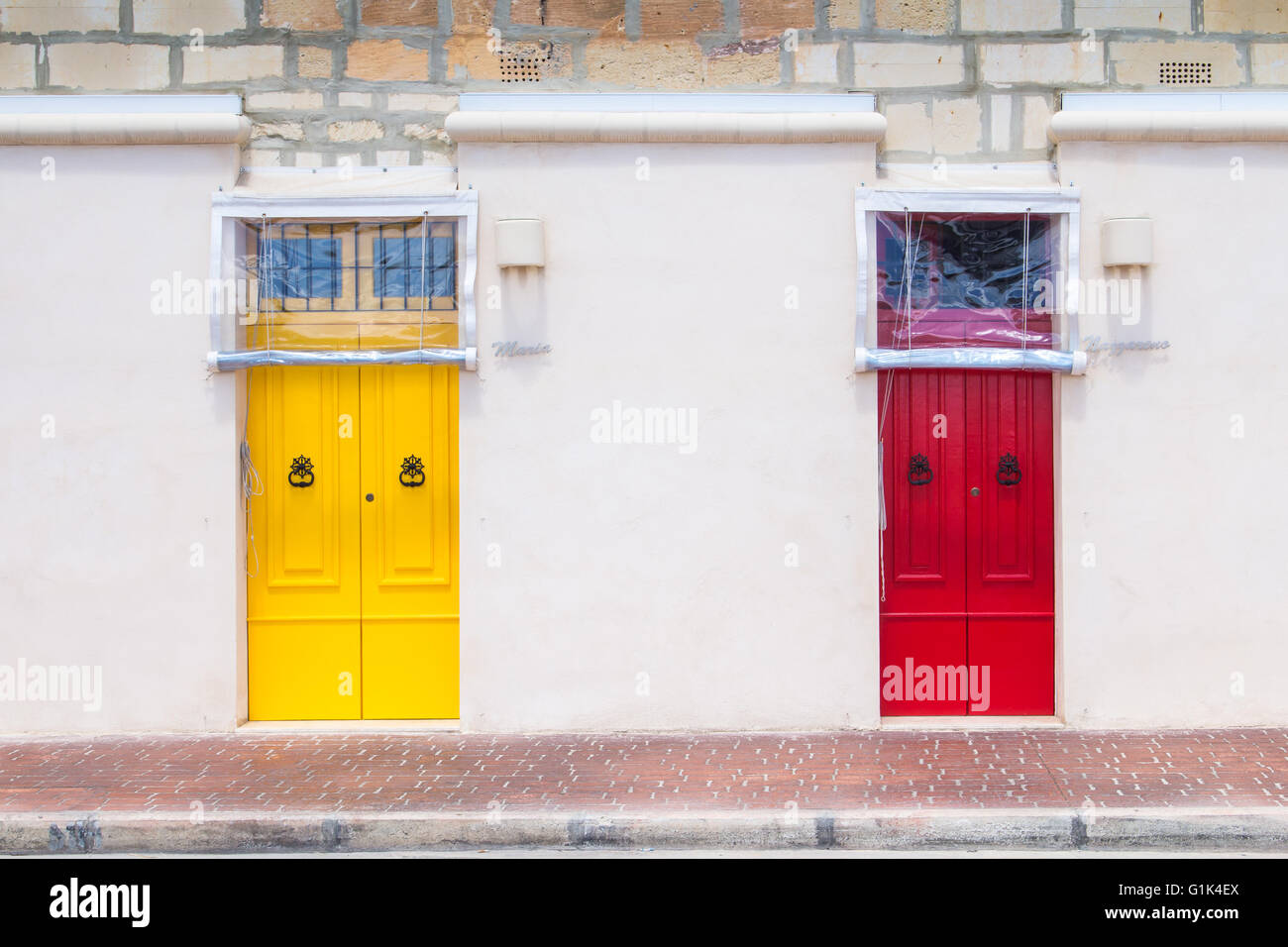 Neutral color of the facade of the house with colorful bright door. Building on the promenade of the fishing village Marsaxlokk, Stock Photo