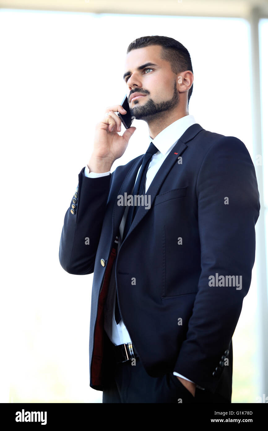 Young businessman standing in office lobby, using smartphone Stock ...