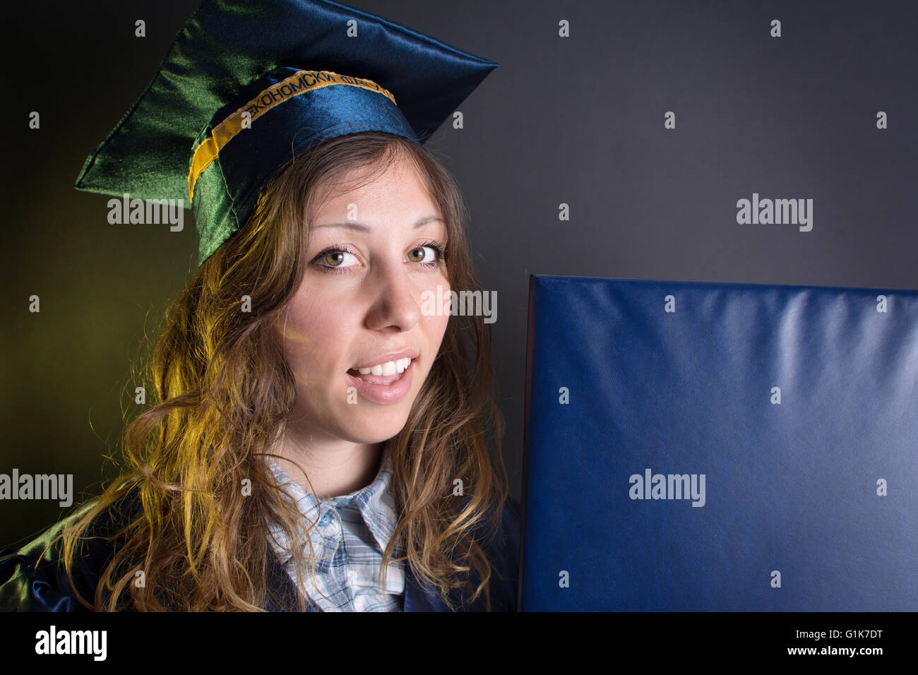 Brunette girl with a diploma in graduation costume and hat Stock Photo