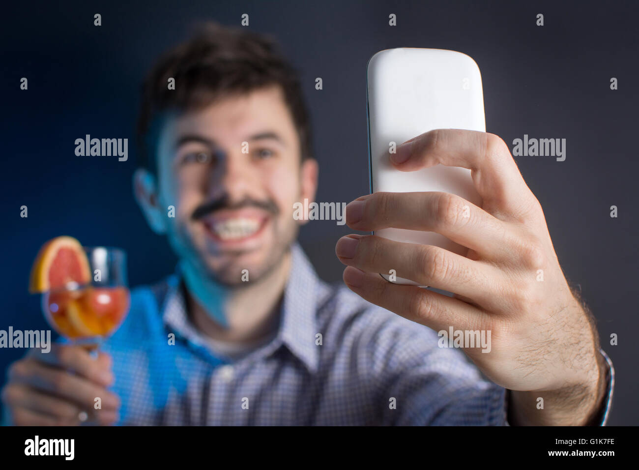 Crazy man making a selfie with a cocktail at the party Stock Photo