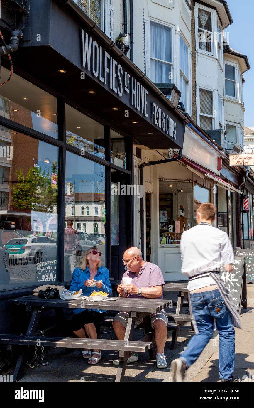 A Middle Aged Couple Eating Fish and Chips Outside Wolfies Fish and Chip Shop, Hove, Sussex, UK Stock Photo