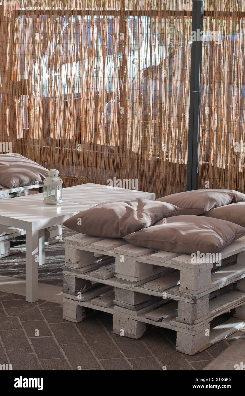 armchairs with cushions made with wood in an outdoor cafe Stock Photo