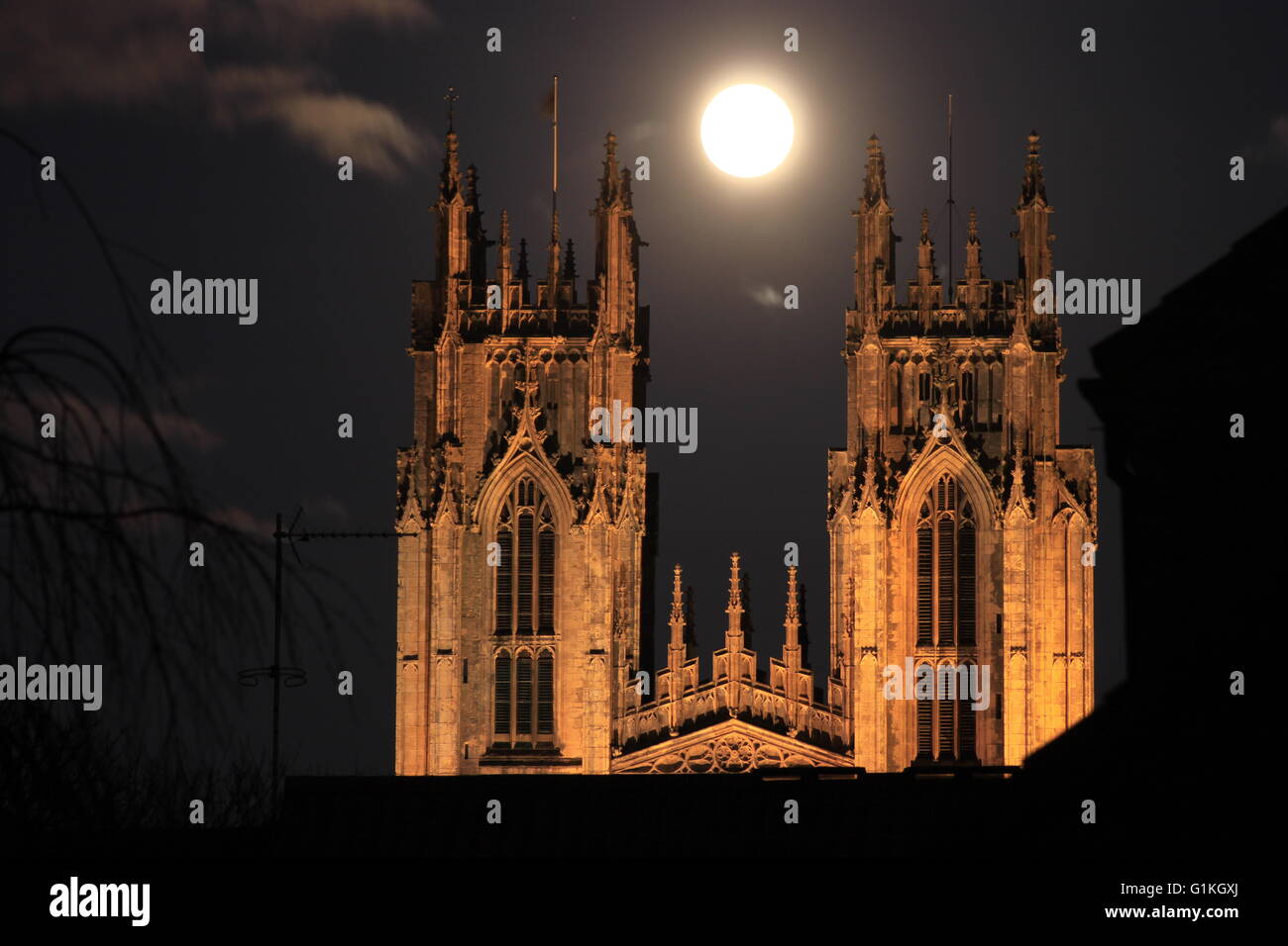 Beverley Minster gothic church floodlit at night with bright moon. Stock Photo