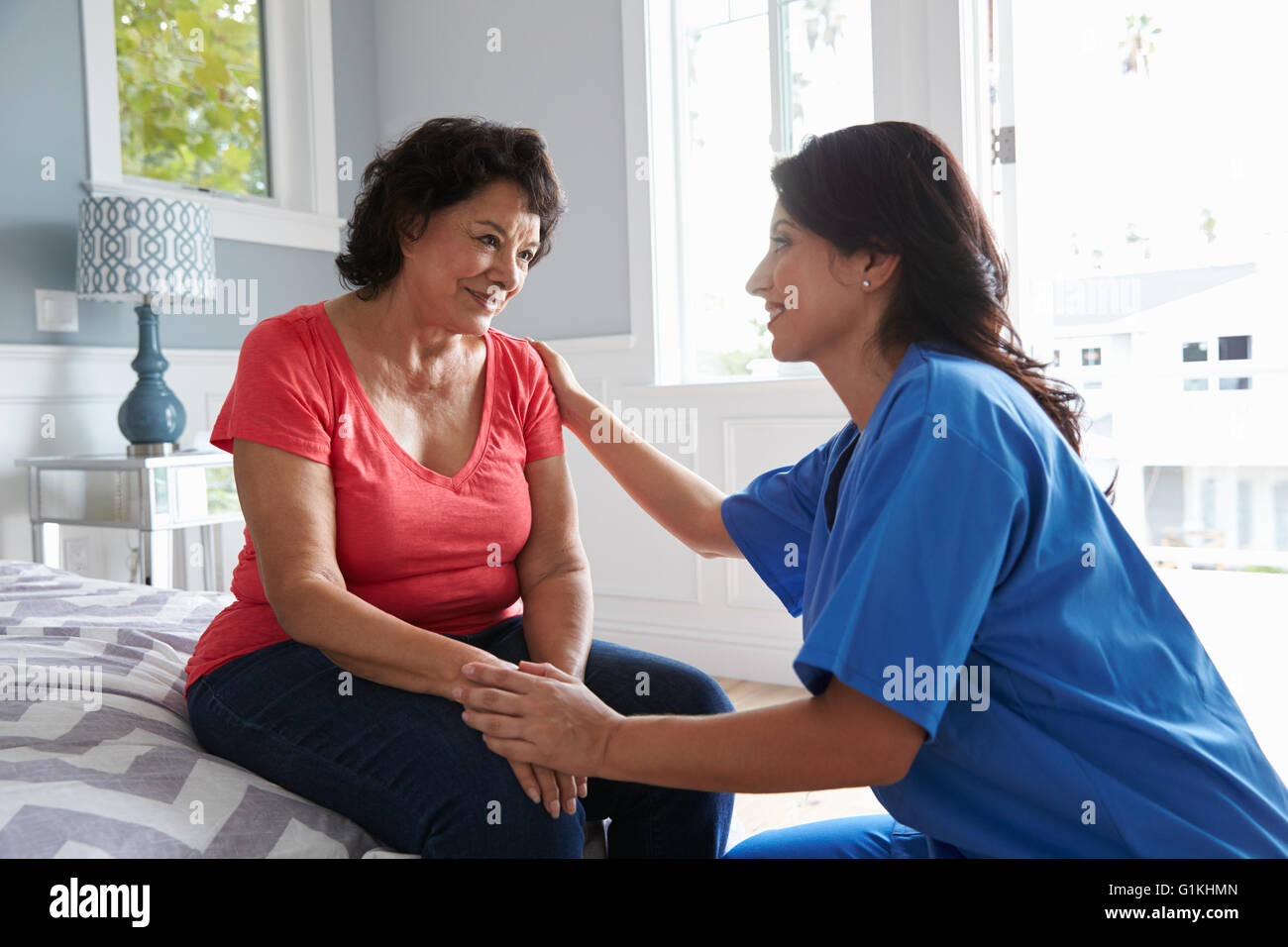 Nurse Making Home Visit To Senior Hispanic Woman Stock Photo