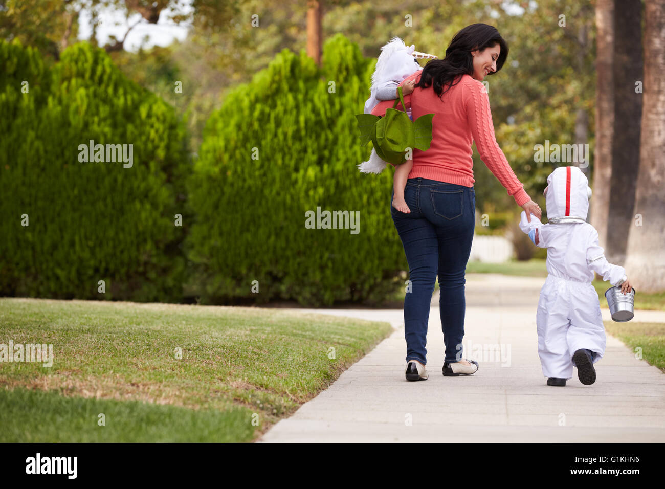 Parent Taking Children Trick Or Treating At Halloween Stock Photo