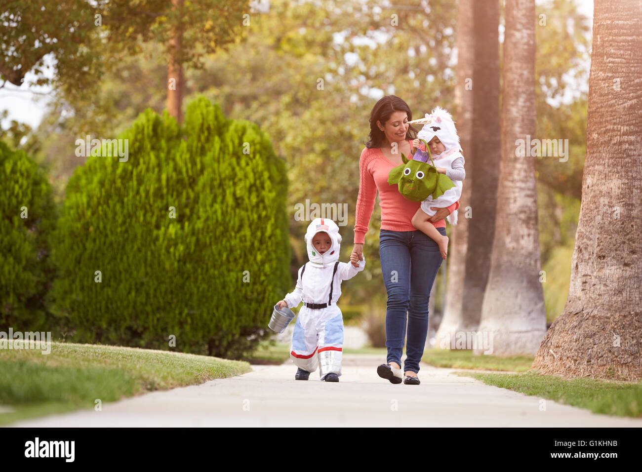 Parent Taking Children Trick Or Treating At Halloween Stock Photo