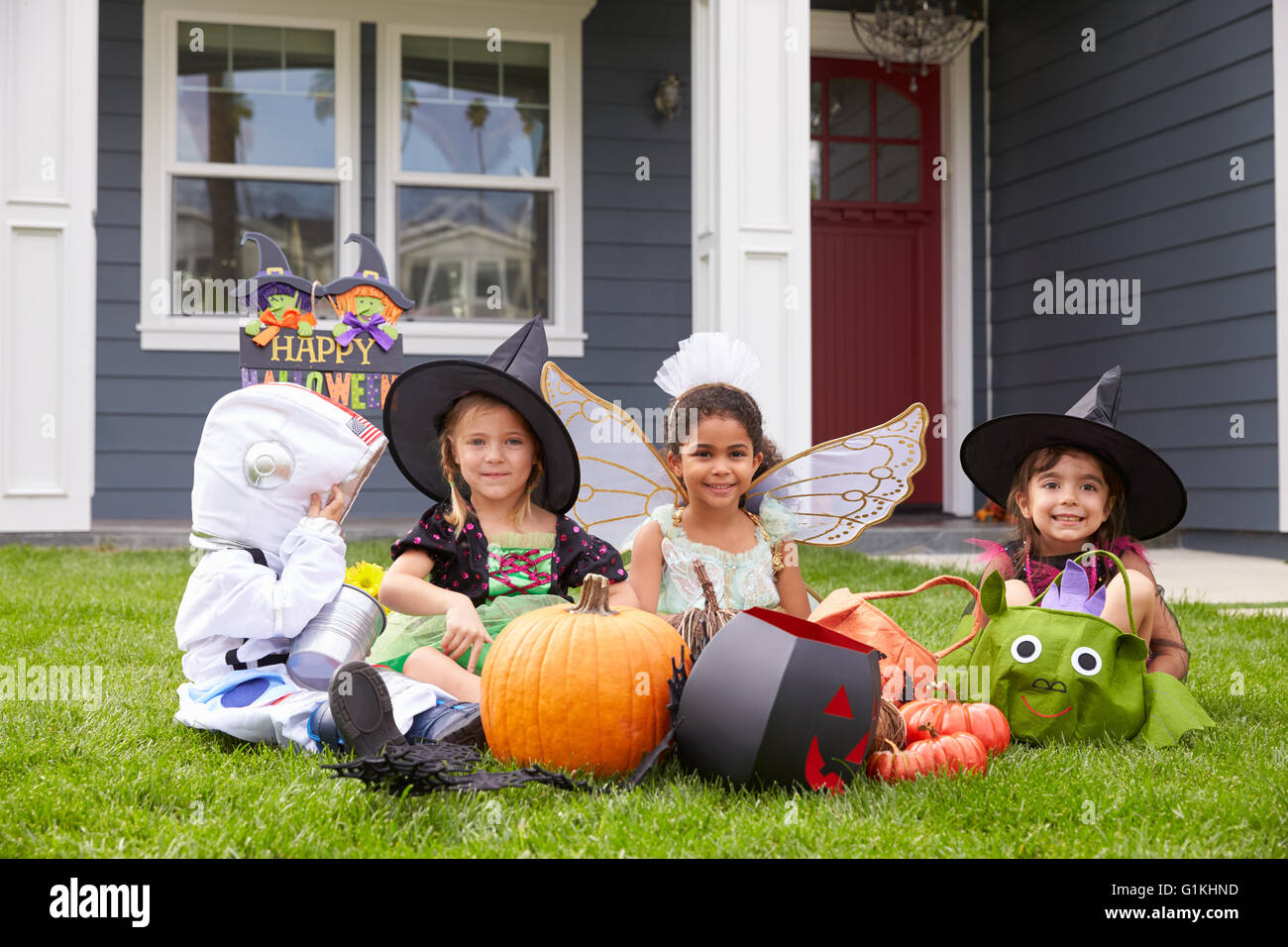 Children Dressed In Trick Or Treating Costumes On Lawn Stock Photo
