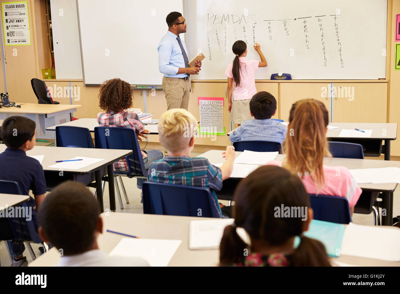 Pupil writing on the board at an elementary school class Stock Photo