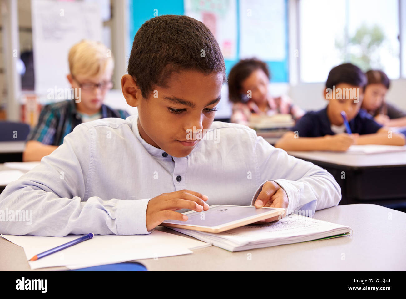 Boy using tablet computer in elementary school class Stock Photo - Alamy