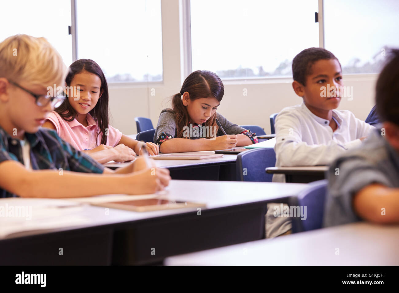 Elementary school kids working at their desks in a classroom Stock ...