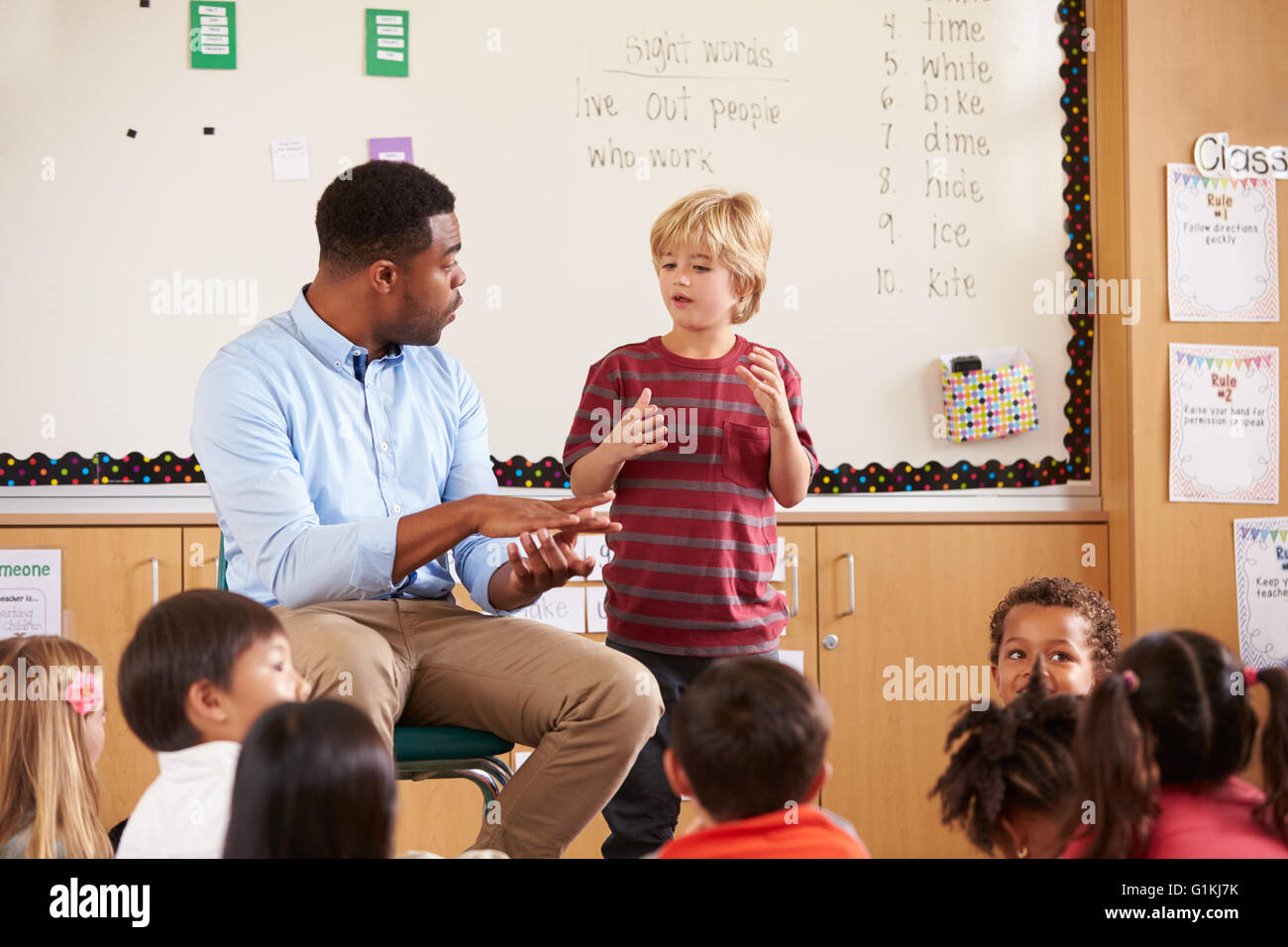 Schoolboy at the front of elementary class with teacher Stock Photo
