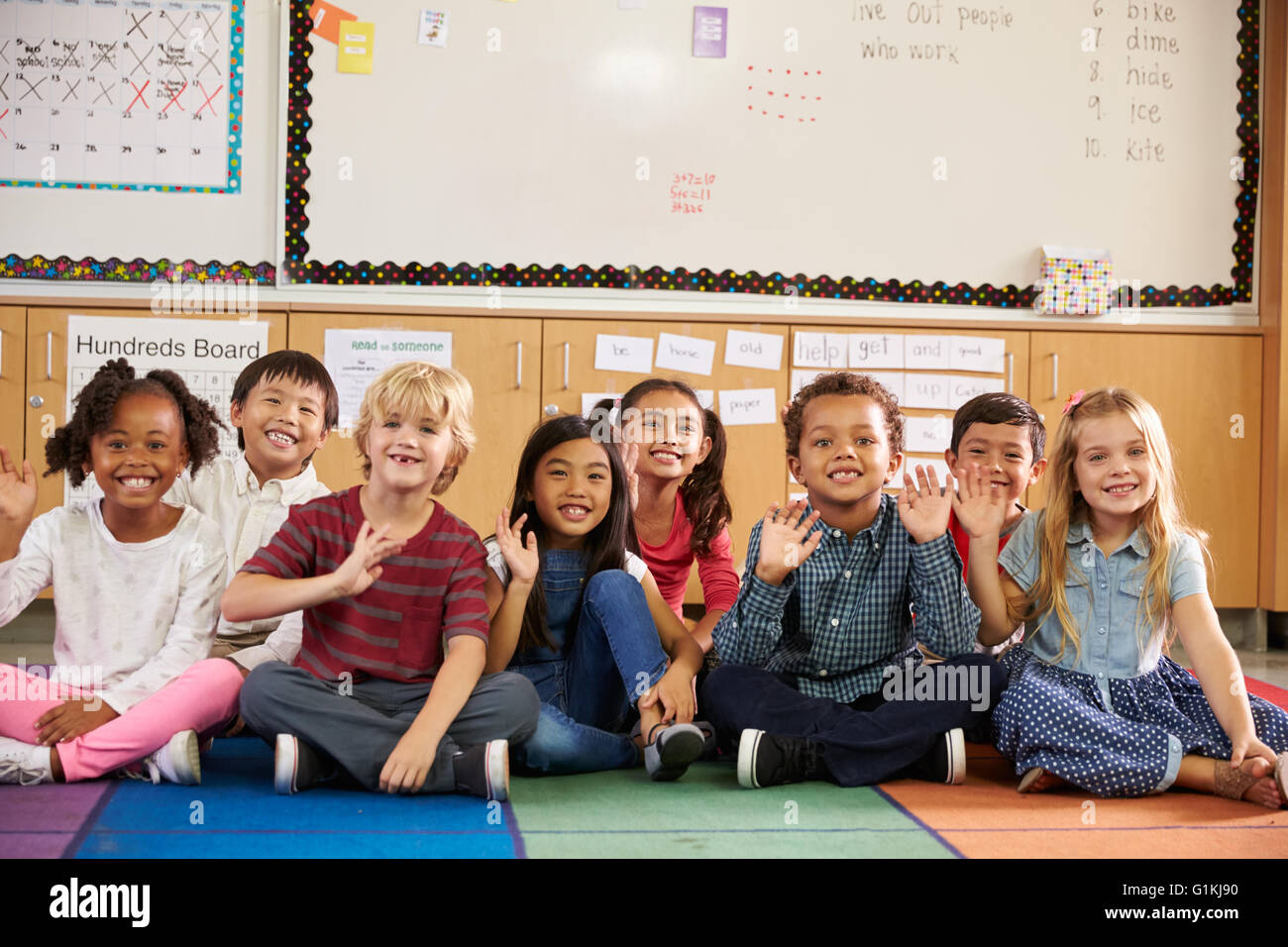 Elementary school kids sitting on classroom floor Stock Photo